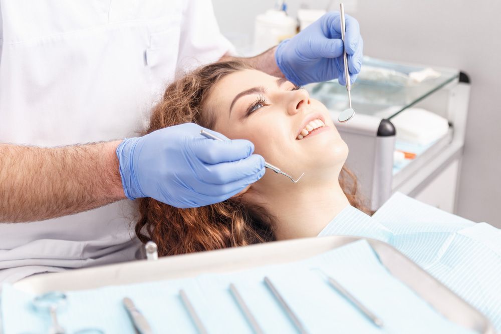 Dentist Examining Patient's Teeth In Dental Clinic — Dentists in Gracemere, QLD