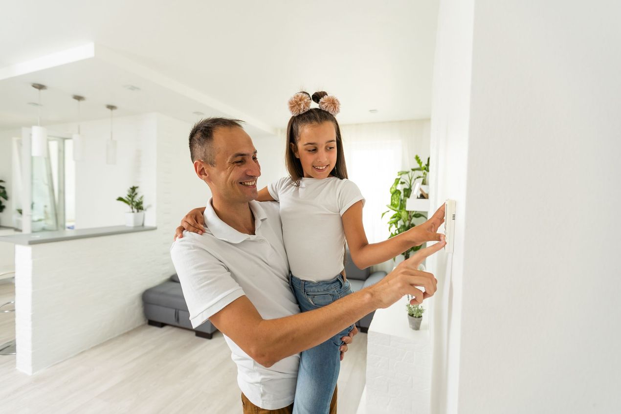 father and daughter change thermostat temperature