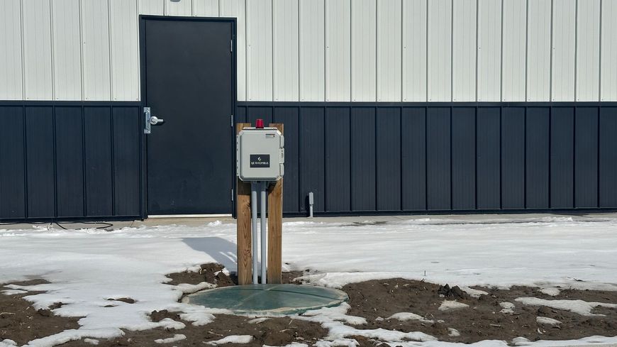 A black door is sitting in front of a building in the snow.