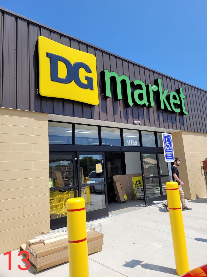 A dg market store with yellow poles in front of it