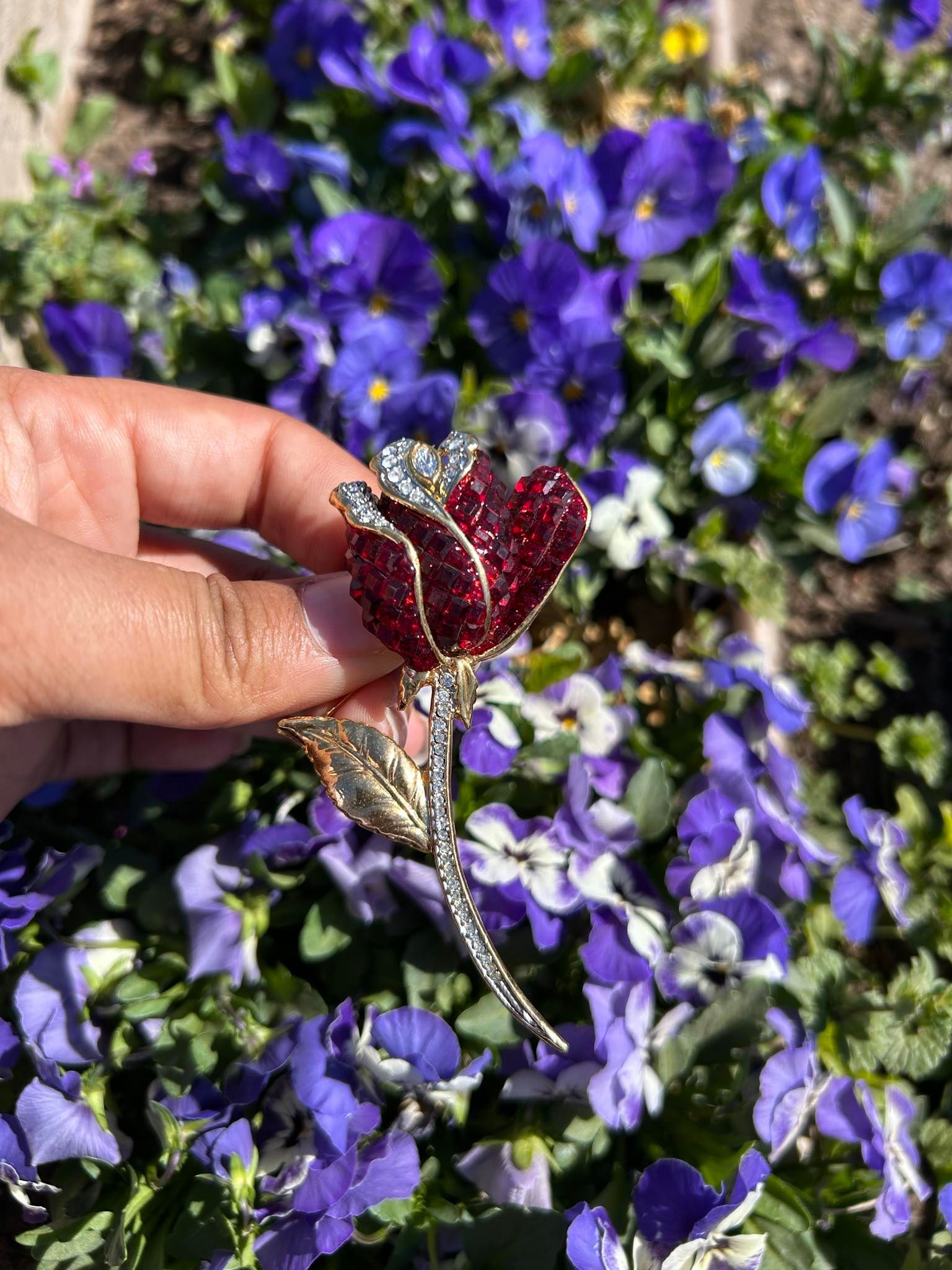 A brooch in the shape of a rose with red and white stones