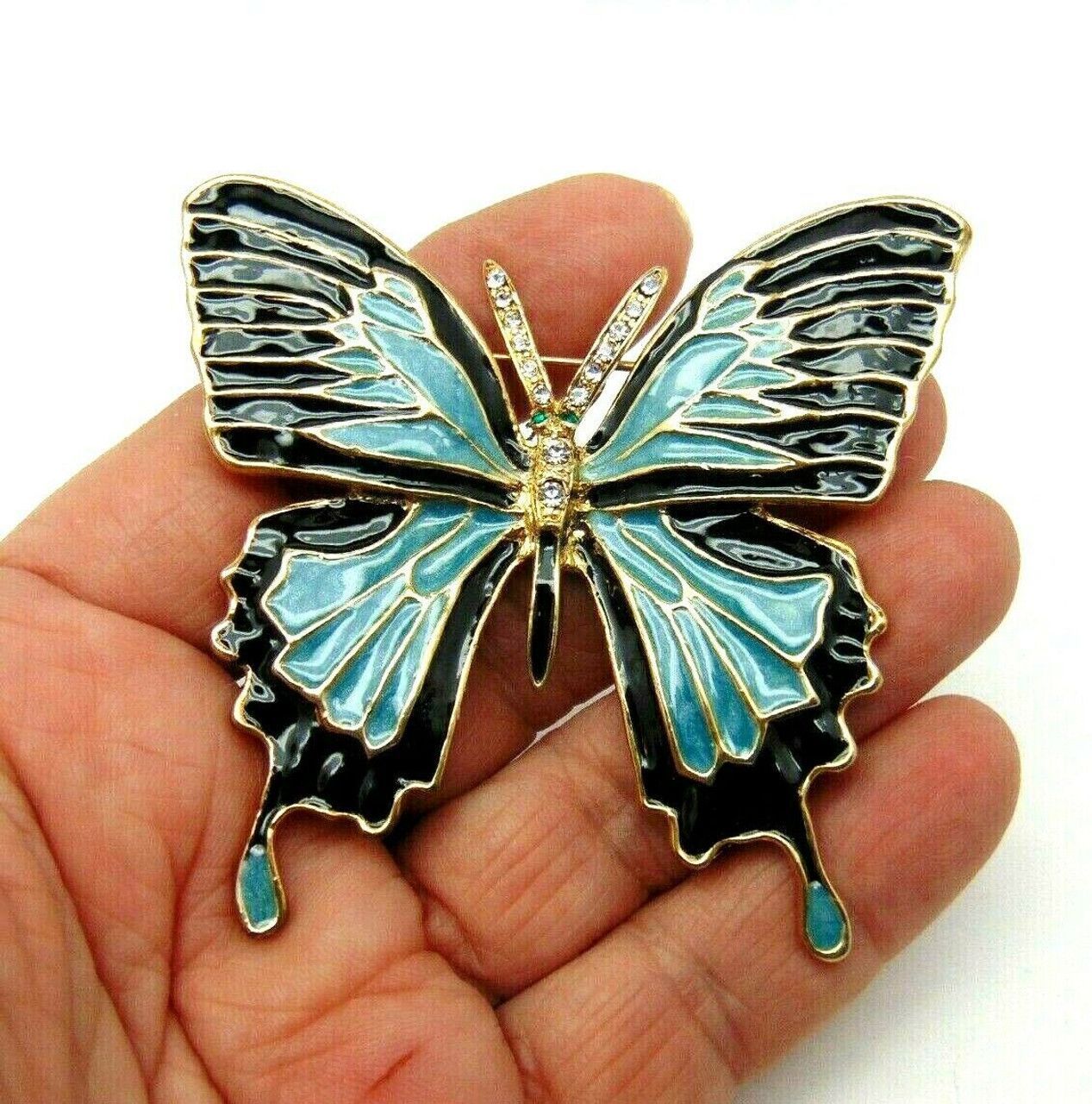 A black and blue butterfly with rhinestones on its wings