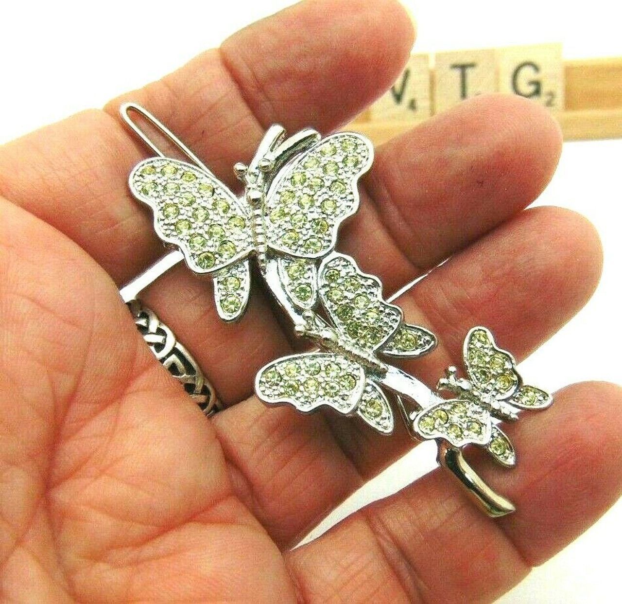 A hair clip with two butterflies on it on a white background.