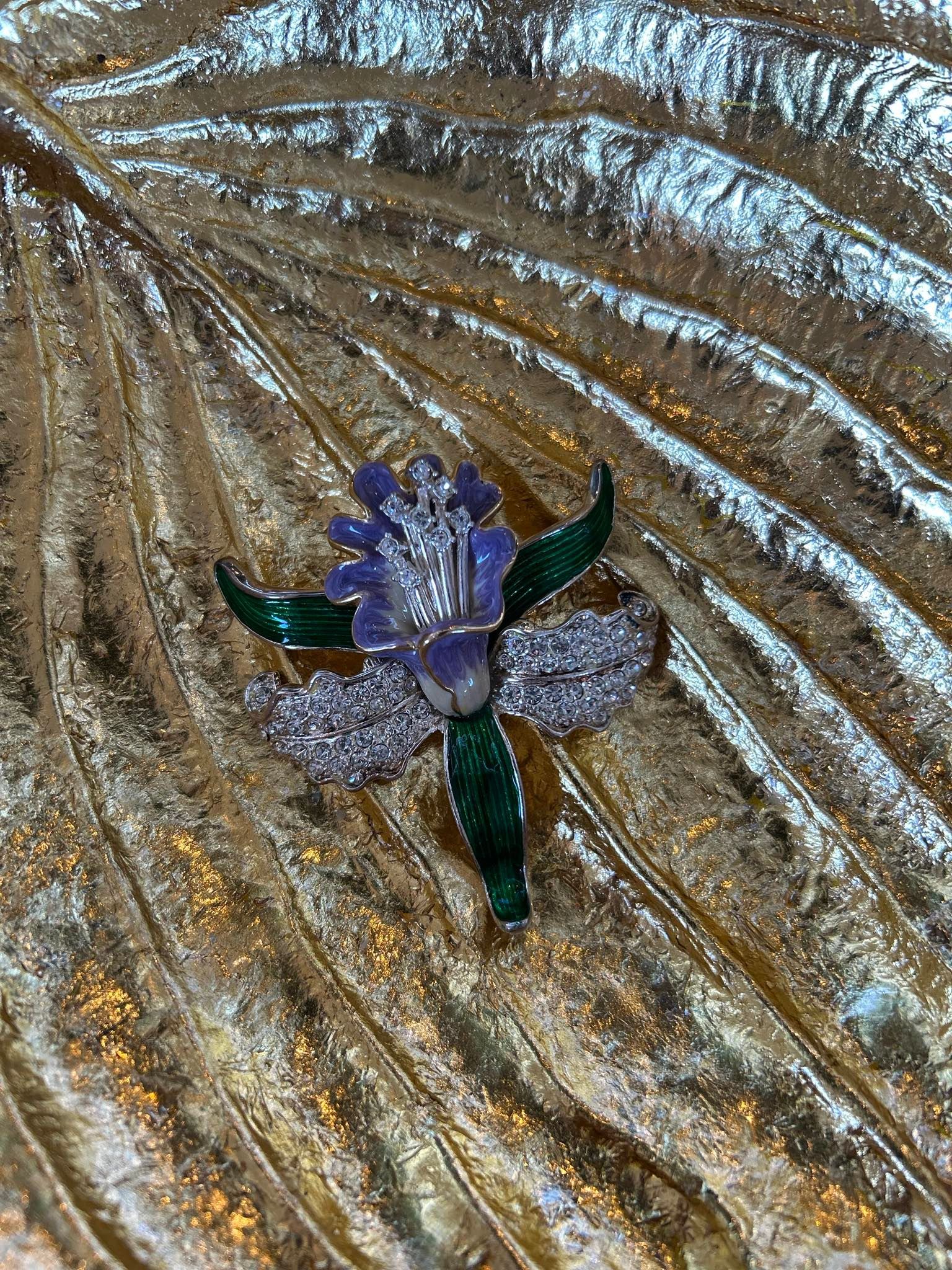 A person is holding a brooch in their hand.