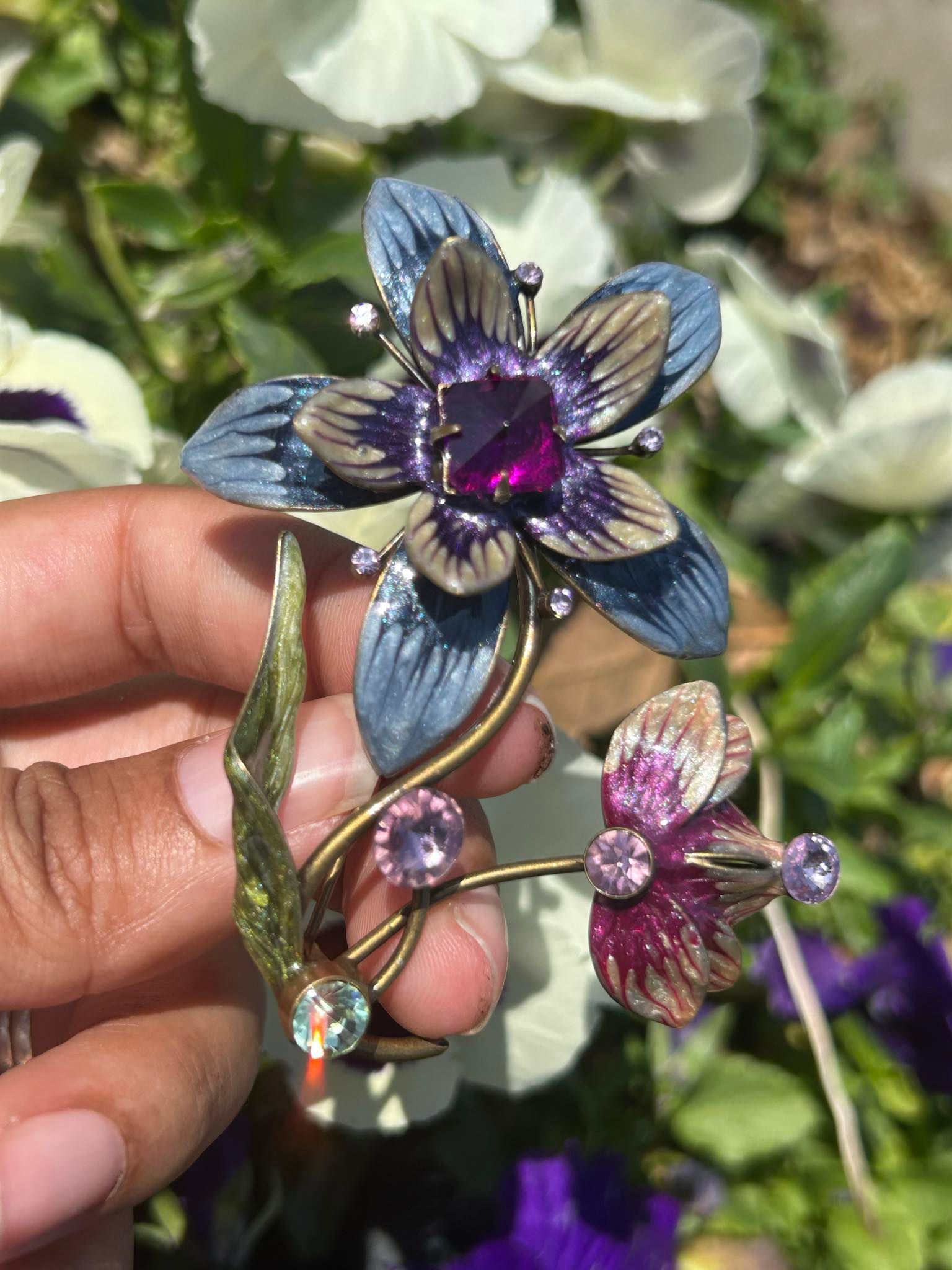 A person is holding a blue flower in front of a bunch of flowers.