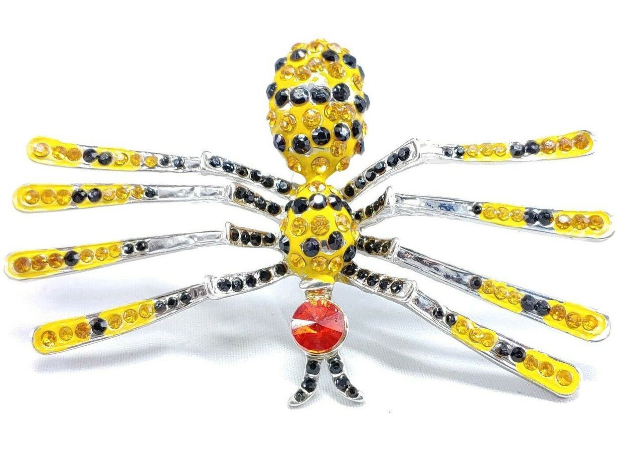 A person is holding a beaded dragonfly in front of a field of flowers.