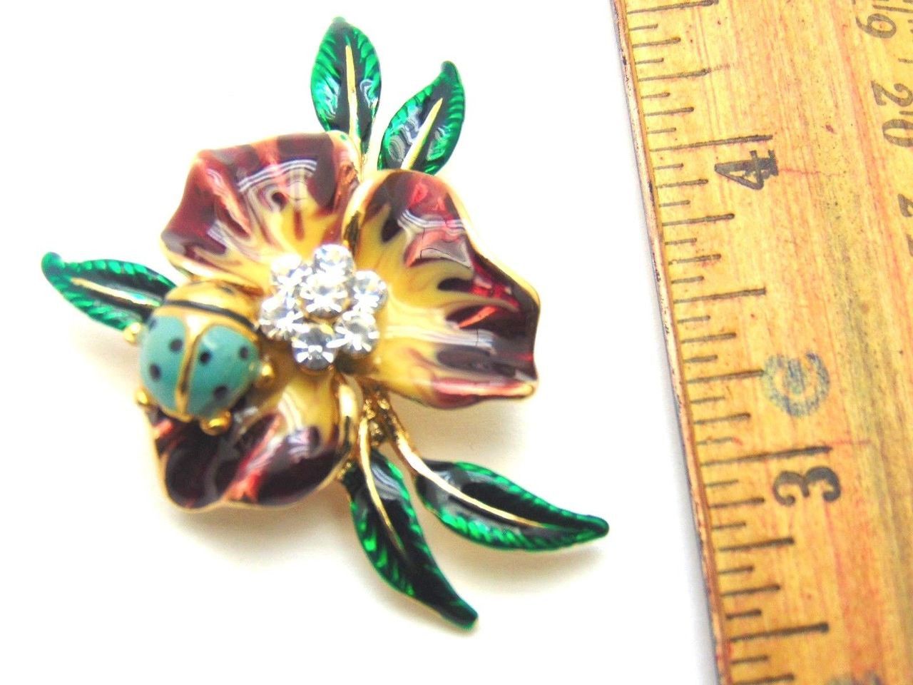 A ladybug is sitting on a flower with green leaves