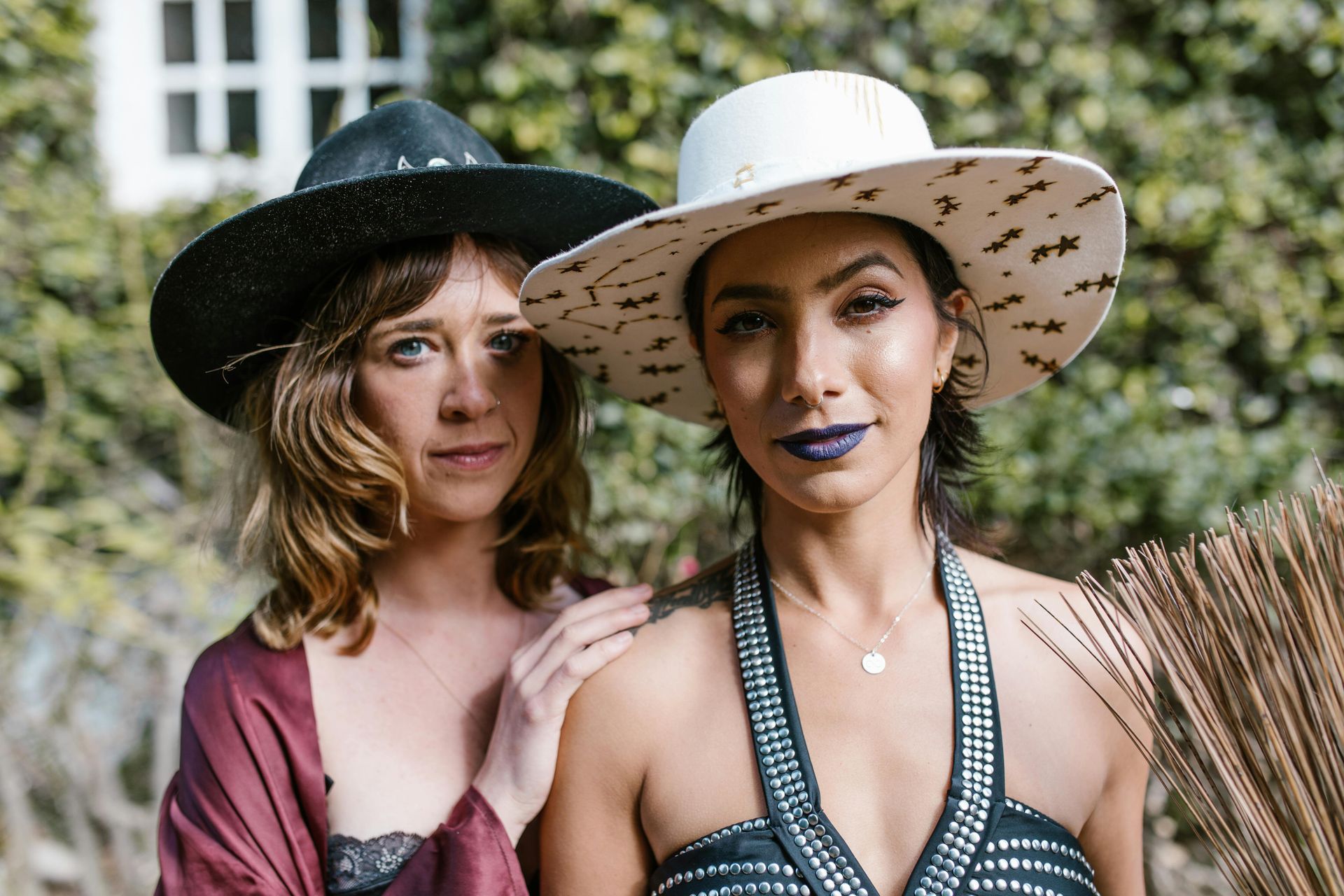 Two women wearing hats are standing next to each other.