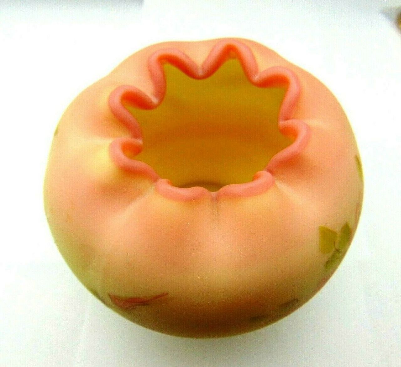 A yellow vase with pink flowers painted on it