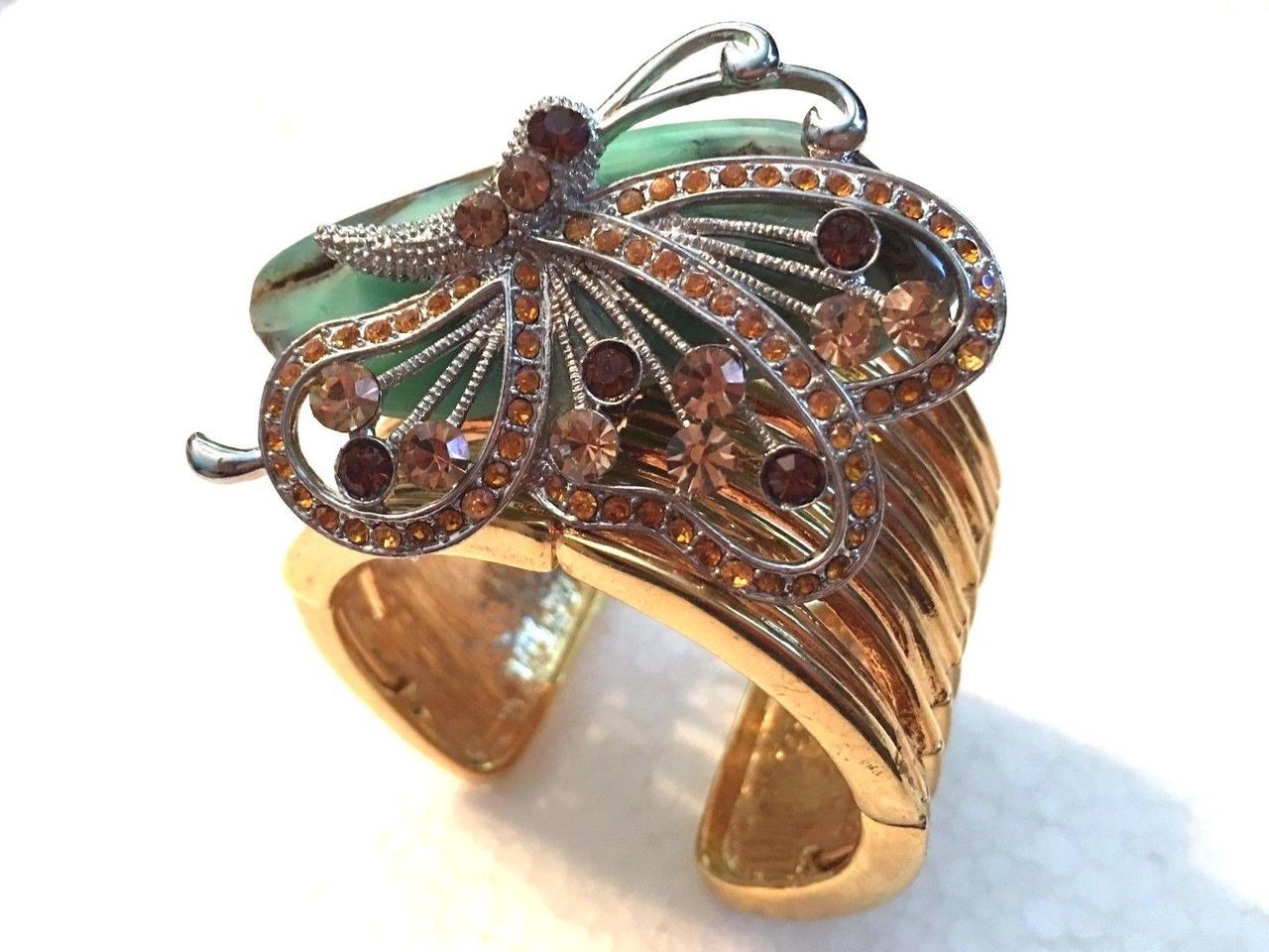 A gold bracelet with a butterfly on it