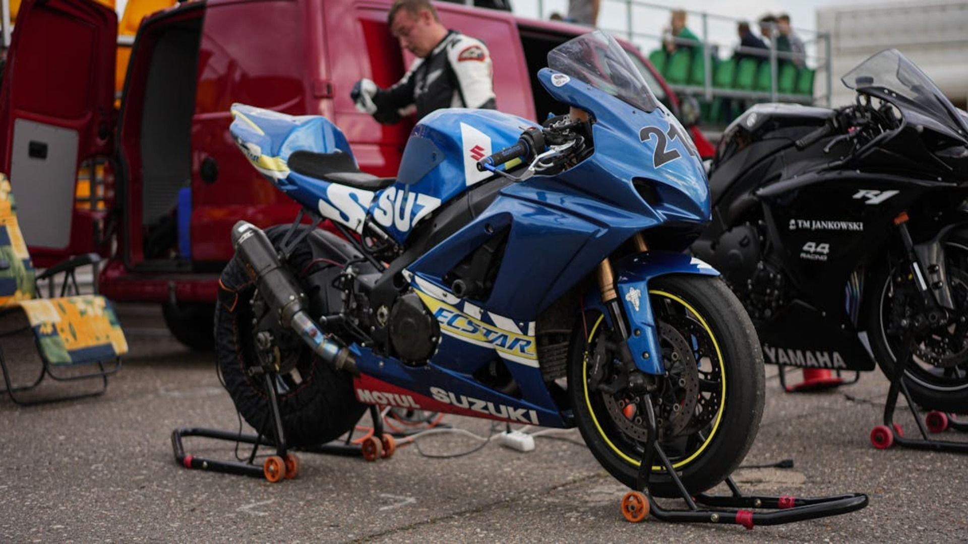 Una motocicleta azul está estacionada al lado de una motocicleta negra.