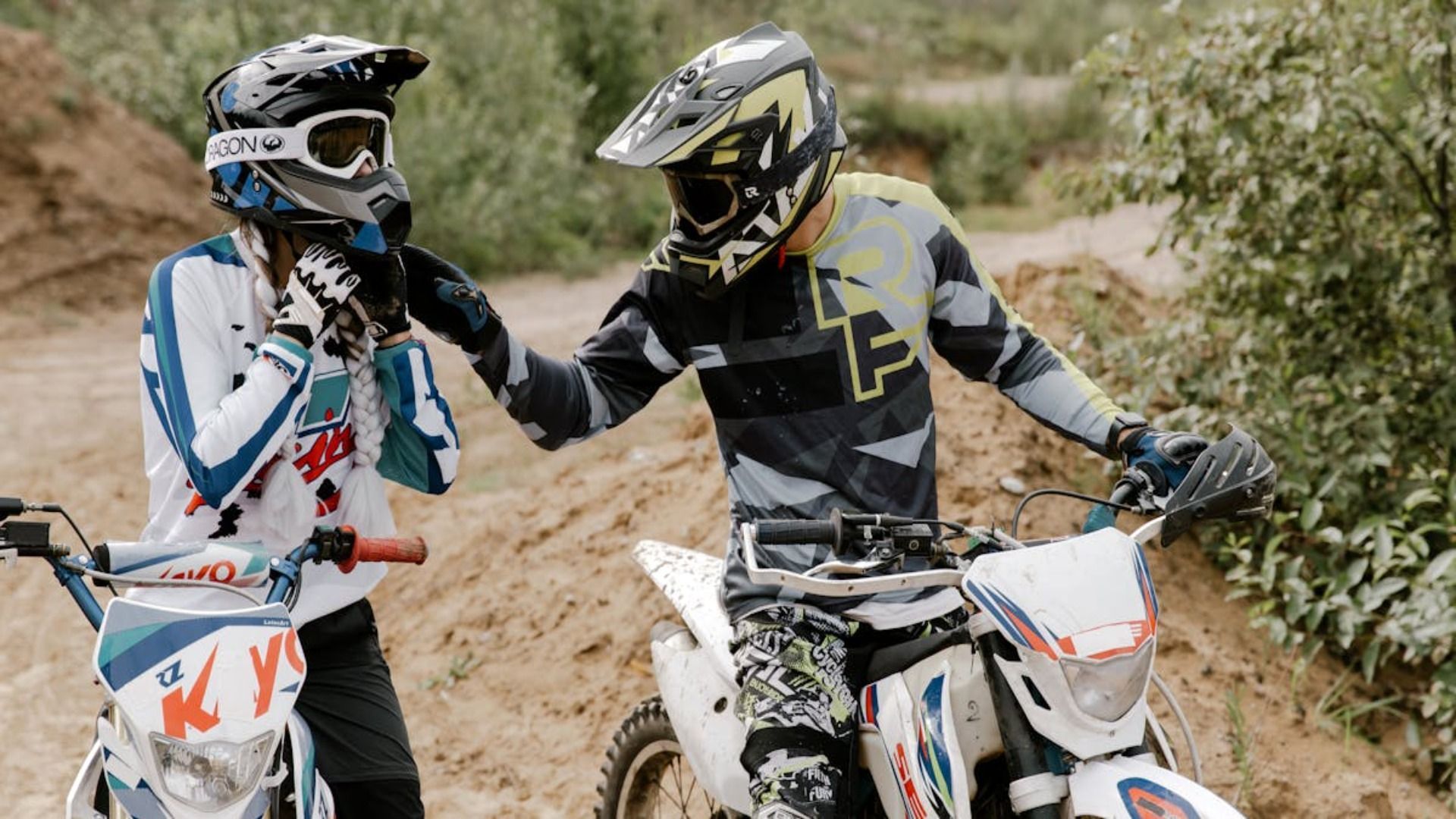 Dos hombres conducen motocicletas todoterreno por un camino de tierra.