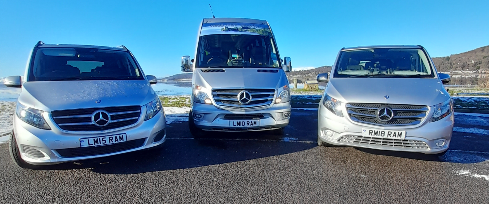 Three mercedes vans are parked next to each other on the side of the road.