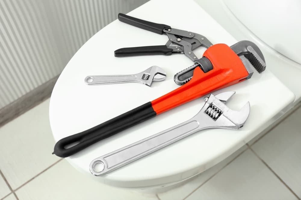 Plumber's Tools On Toilet Seat Lid — Mainline Plumbing & Civil Pty Ltd In Dubbo, NSW