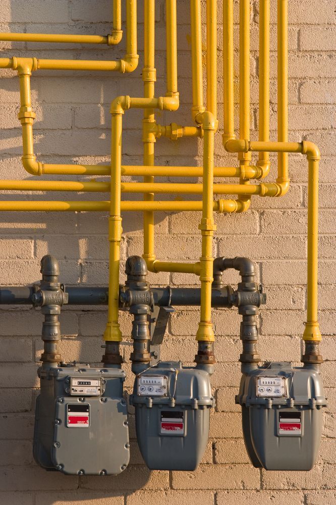 A Row of Gas Meters on a Brick Wall — Mainline Plumbing & Civil Pty Ltd In Dubbo, NSW
