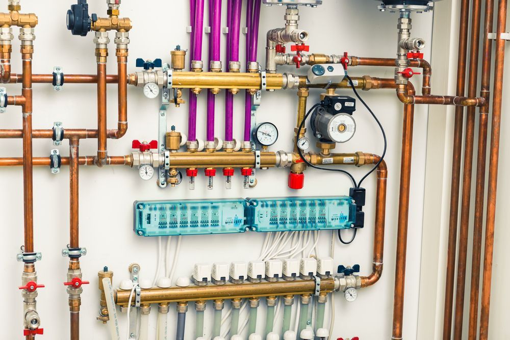 A Bunch of Copper Pipes Are Hanging on a Wall — Mainline Plumbing & Civil Pty Ltd In Walgett, NSW