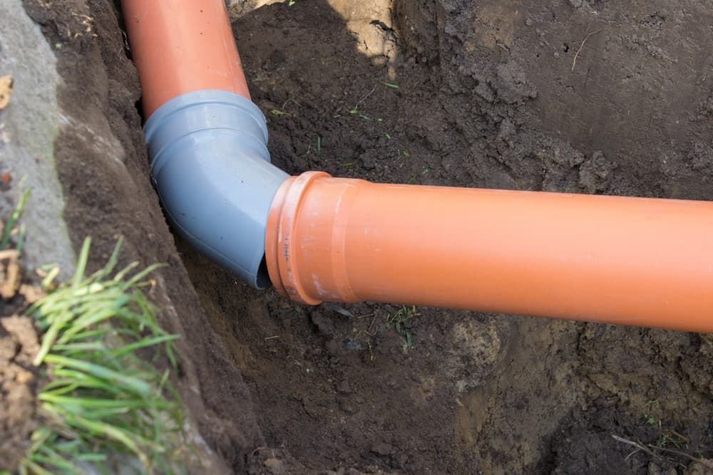 A Couple of Pipes Are Connected to Each Other in the Dirt — Mainline Plumbing & Civil Pty Ltd In Wellington, NSW