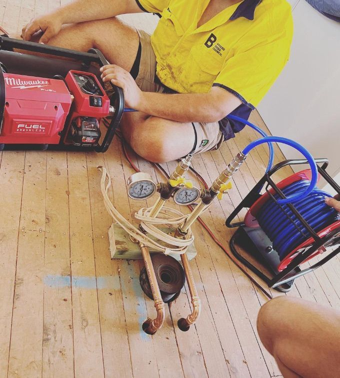 A Man Wearing a Yellow Shirt With the Letter B on It — Mainline Plumbing & Civil Pty Ltd In Dubbo, NSW