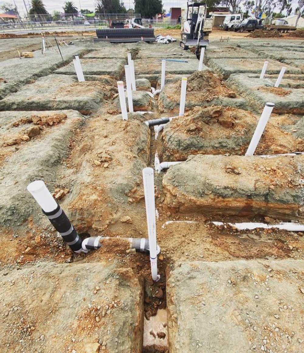 A Construction Site With a Lot of Pipes in the Dirt — Mainline Plumbing & Civil Pty Ltd In Dubbo, NSW