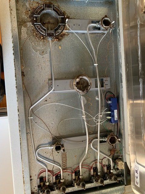 The Inside of a Stove With a Lot of Wires Coming Out of It — Mainline Plumbing & Civil Pty Ltd In Dubbo, NSW