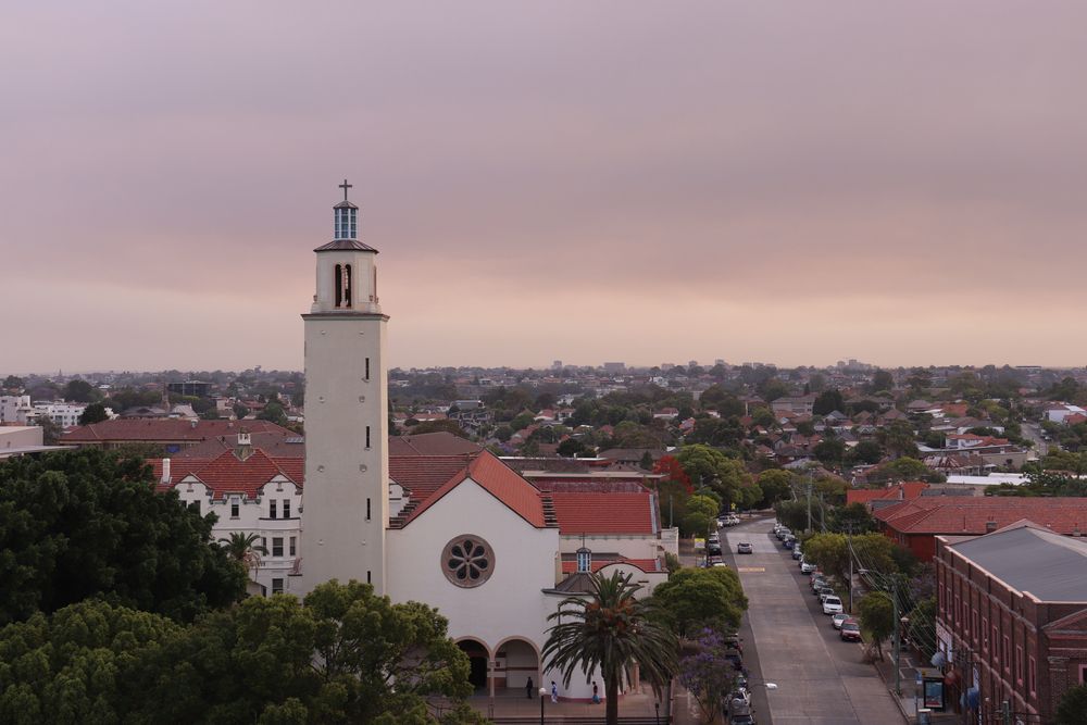An Aerial View of a Church With a Clock Tower — Mainline Plumbing & Civil Pty Ltd In Marrickville, NSW