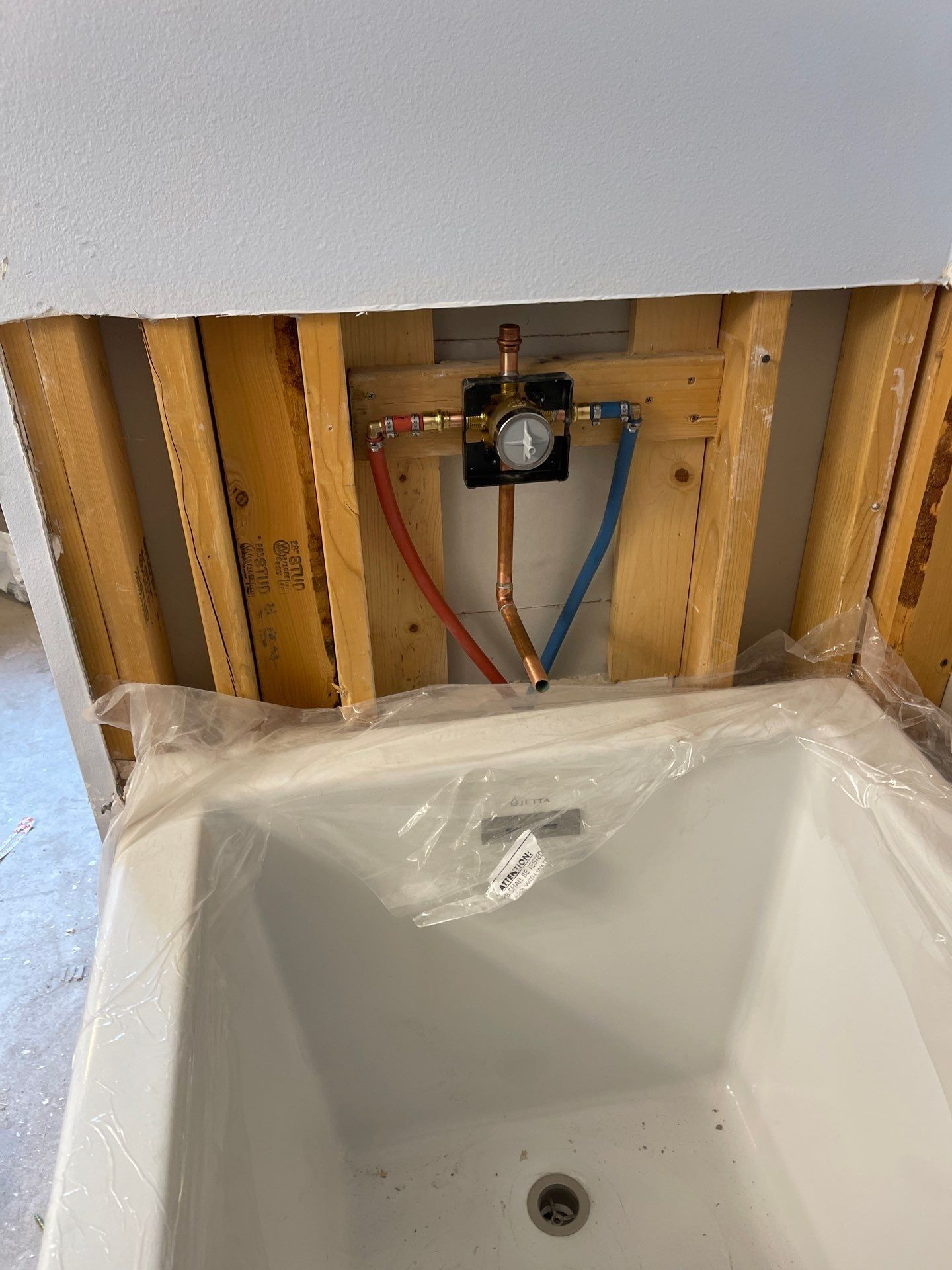 Bathroom sink under construction with exposed plumbing and unfinished wall framing