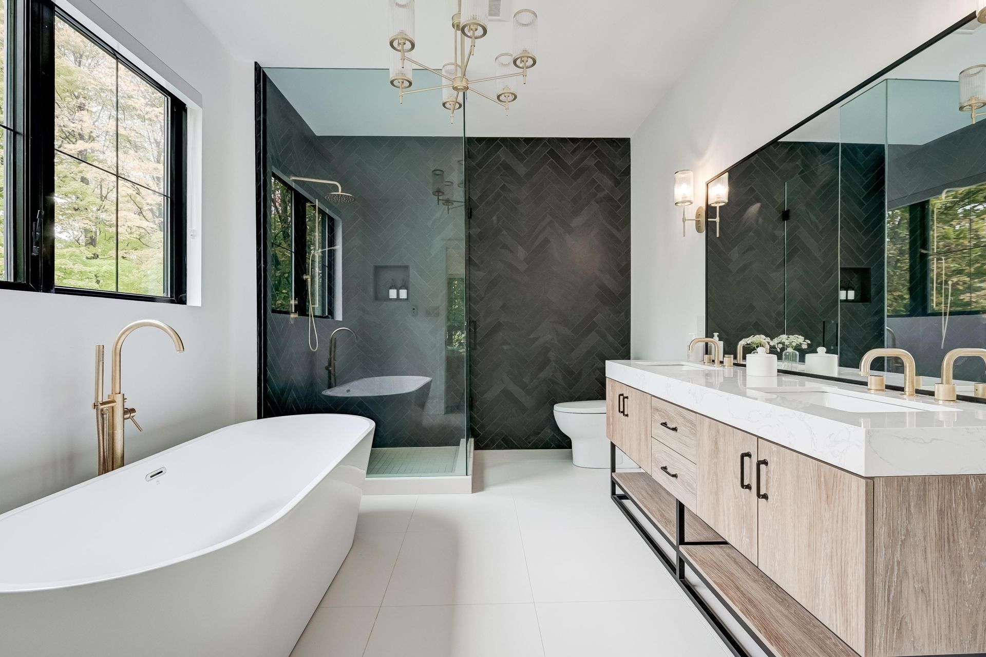 Modern bathroom with freestanding tub, walk-in shower, double vanity, and black-framed windows