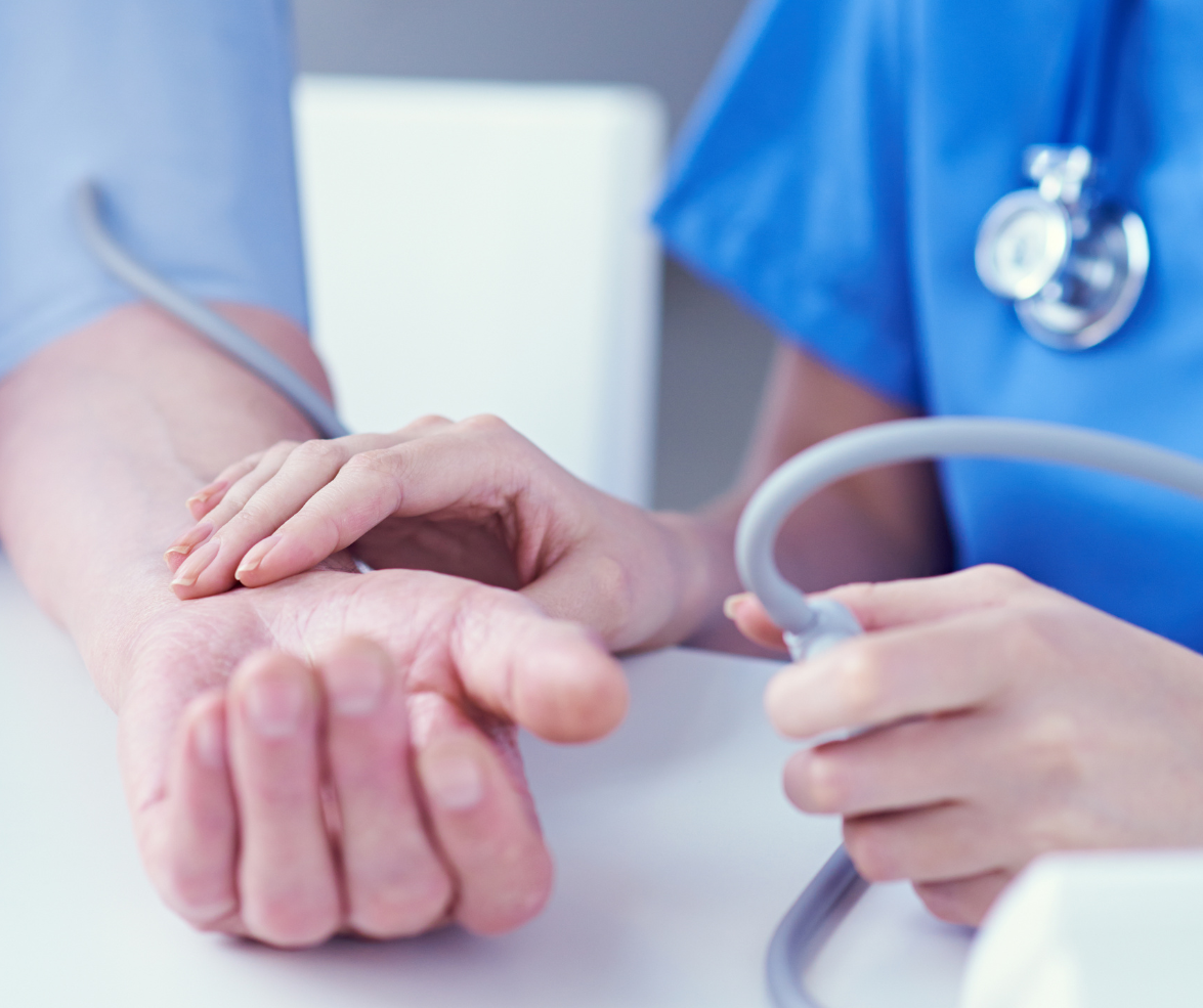 Nurse taking a patient's blood pressure with stethoscope and cuff.