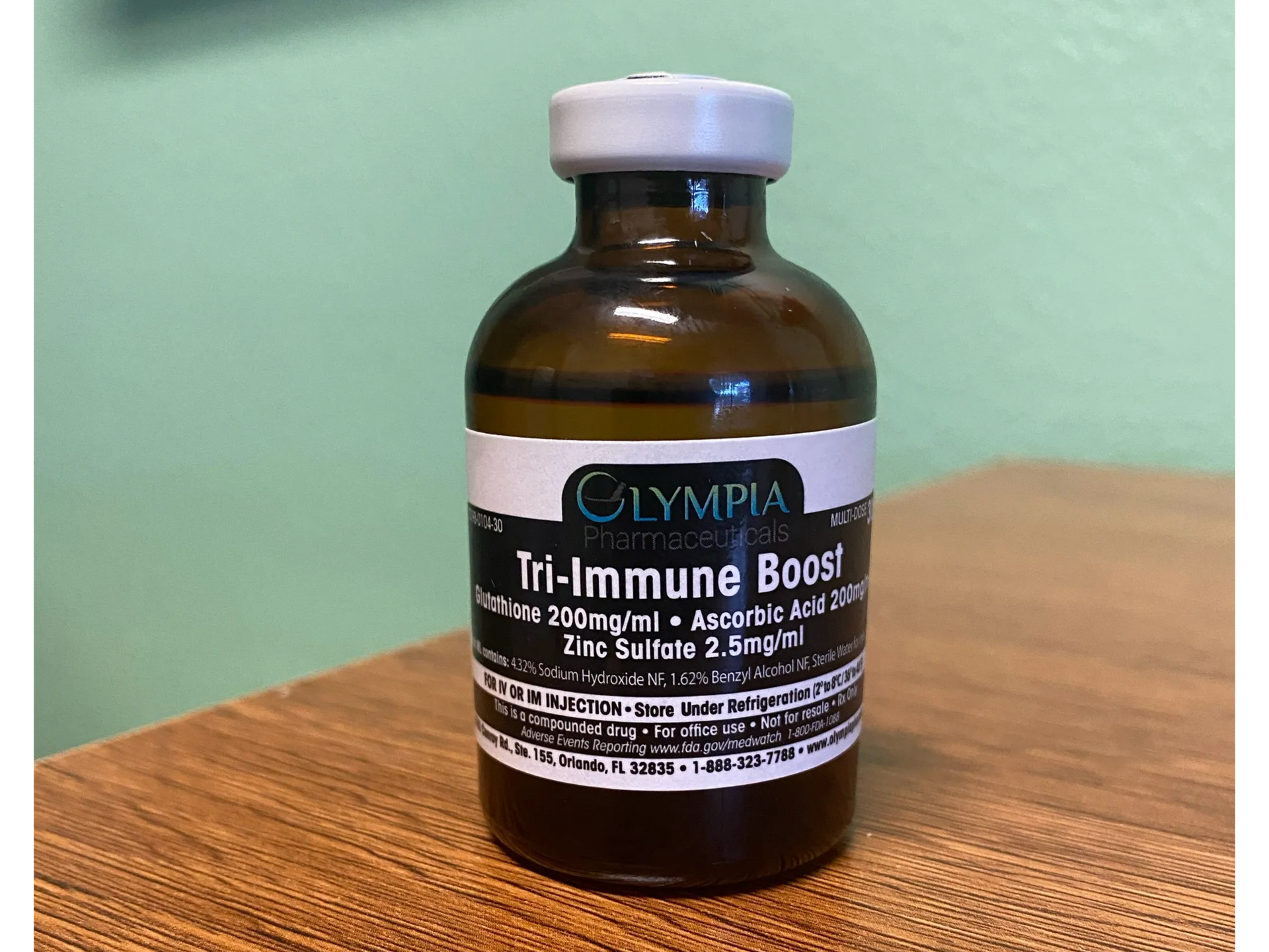 A bottle of tri-immune boost is sitting on a wooden table.
