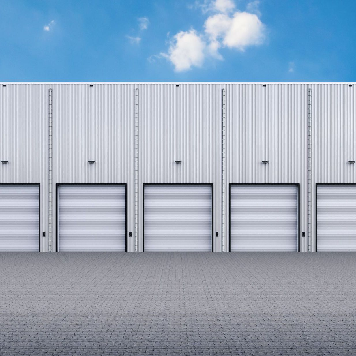 a row of white garage doors on a building with a blue sky in the background .