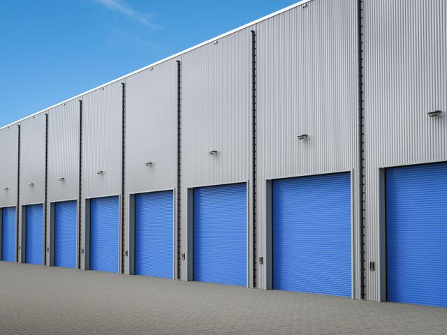 a row of blue garage doors on a building