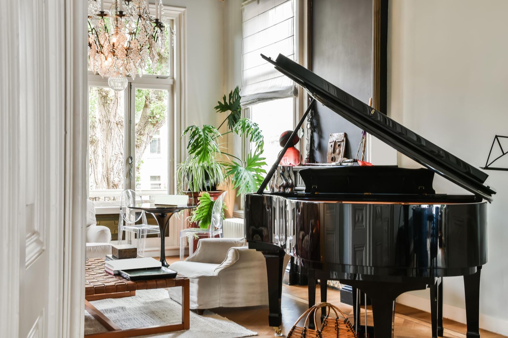 a piano is sitting in a living room next to a window .