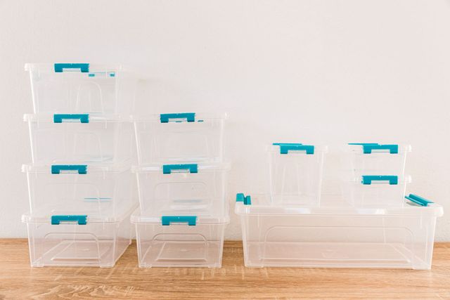 a bunch of clear plastic containers are stacked on top of each other on a wooden table .