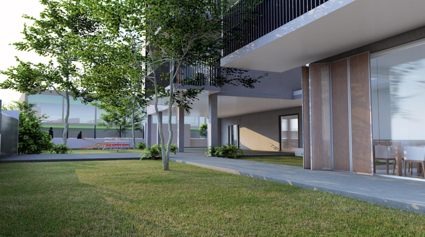 Césped verde, árboles y un edificio moderno con grandes ventanales.