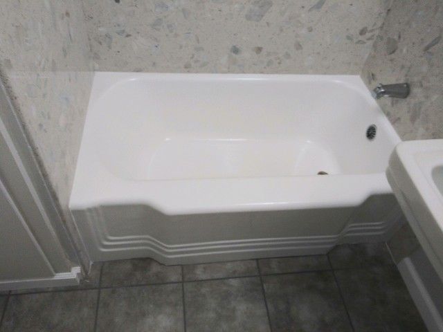 a white bathtub in a bathroom next to a sink