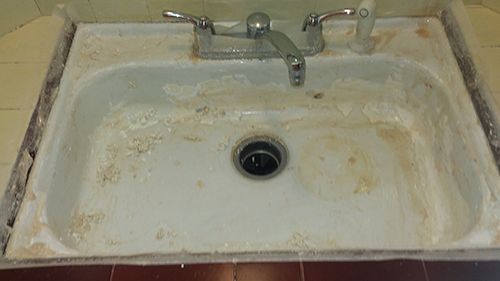 a dirty sink with a faucet in a bathroom .
