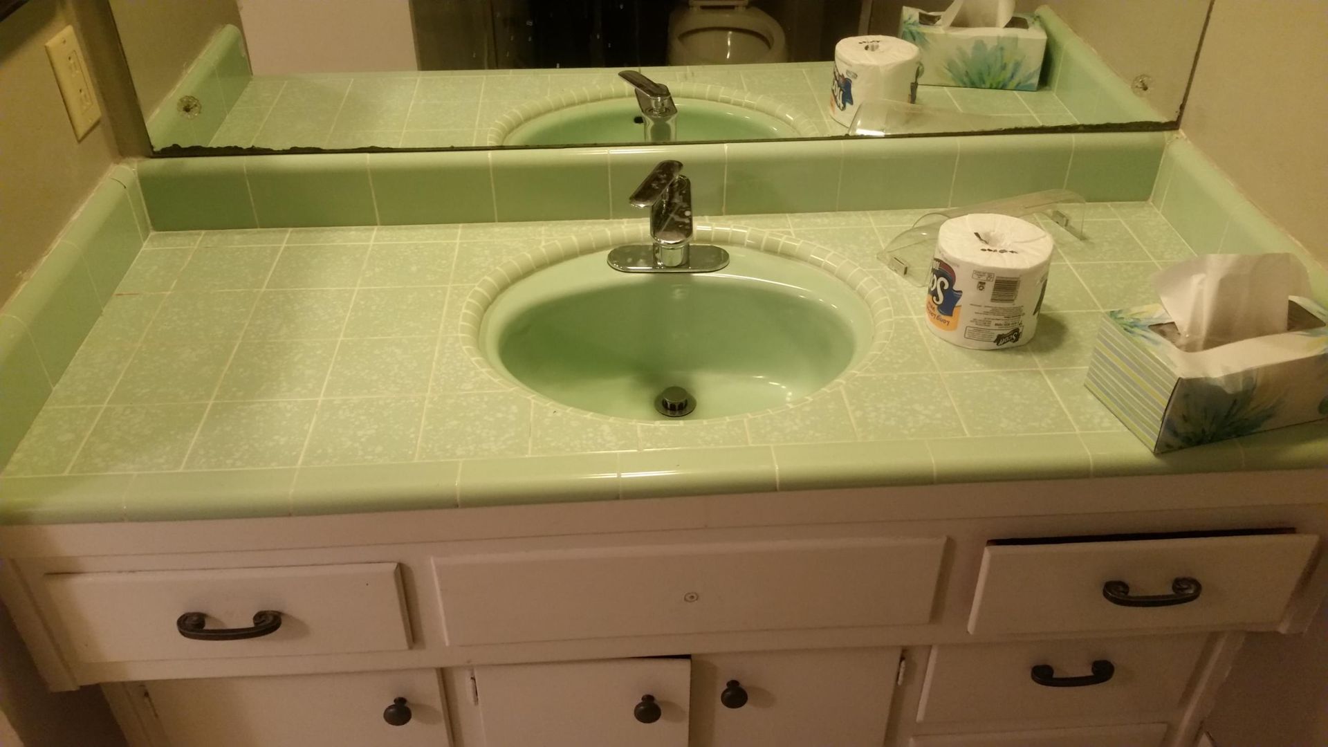 a bathroom counter with a sink and a box of tissues