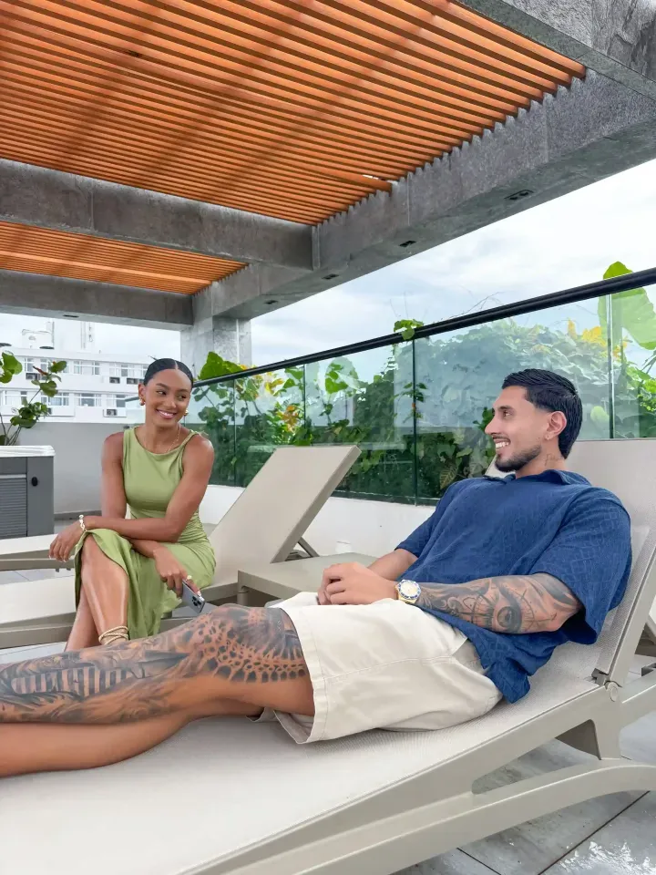 Pareja disfrutando de sillones lounge en el rooftop del Delamar Hotel en San Andrés, plan romántico frente al mar Caribe.