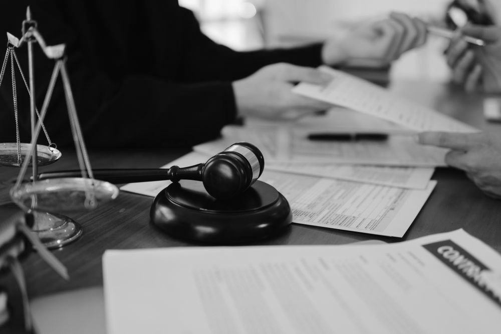 Judge's gavel on desk with legal documents and a scales of justice in the foreground - ev law in Bundall, QLD