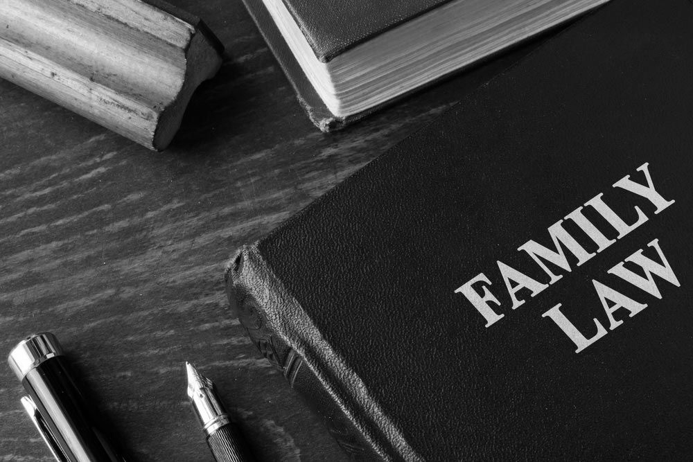 Family law books and a gavel on a desk in black and white - ev law in Bundall, QLD