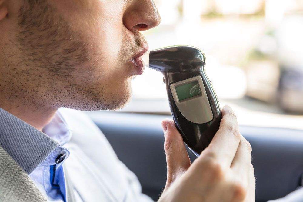 Man Using A Breath Analyser Inside His Car