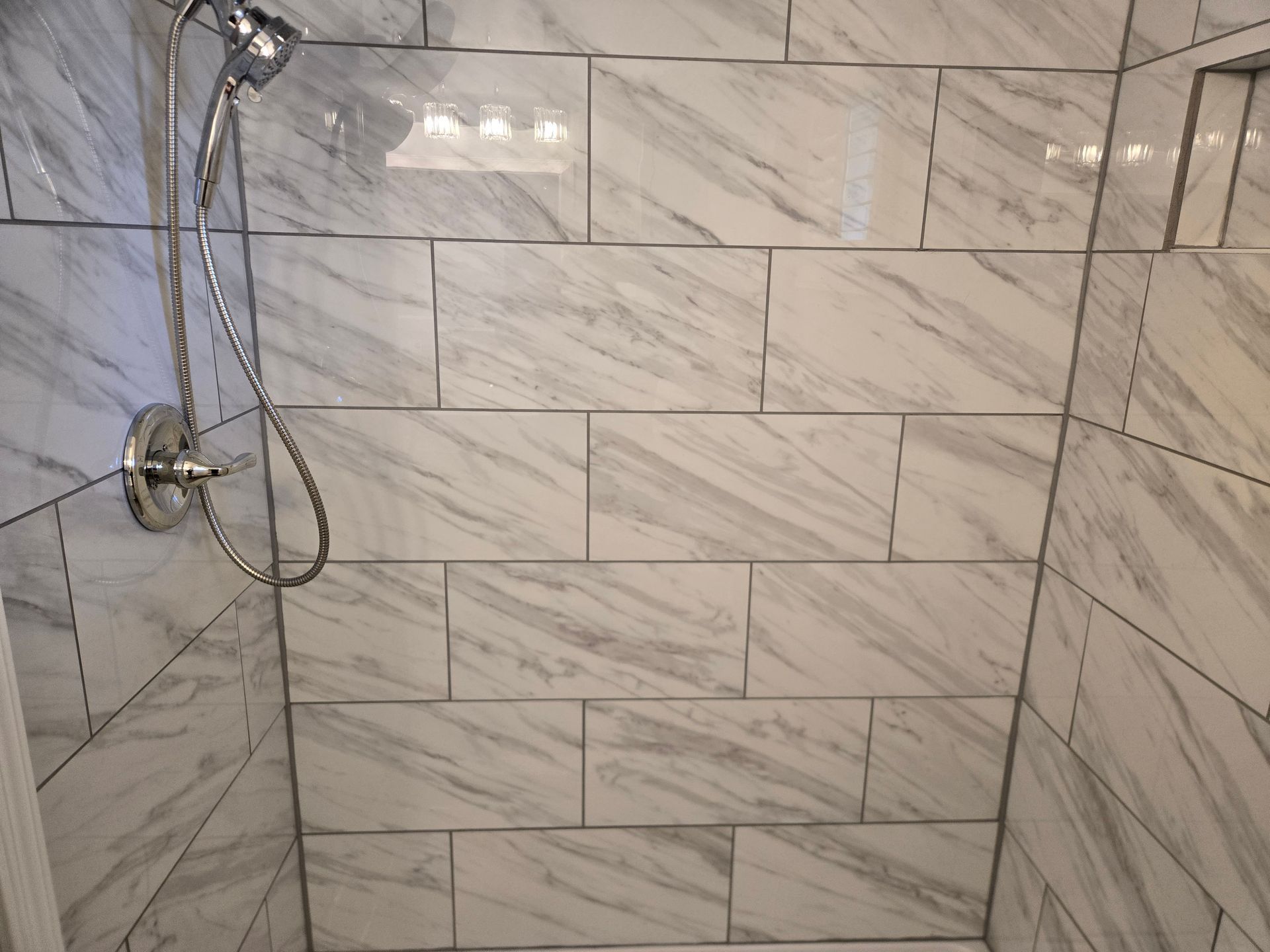 Modern bathroom with marble shower, soaking tub, vanity, skylight, and window.