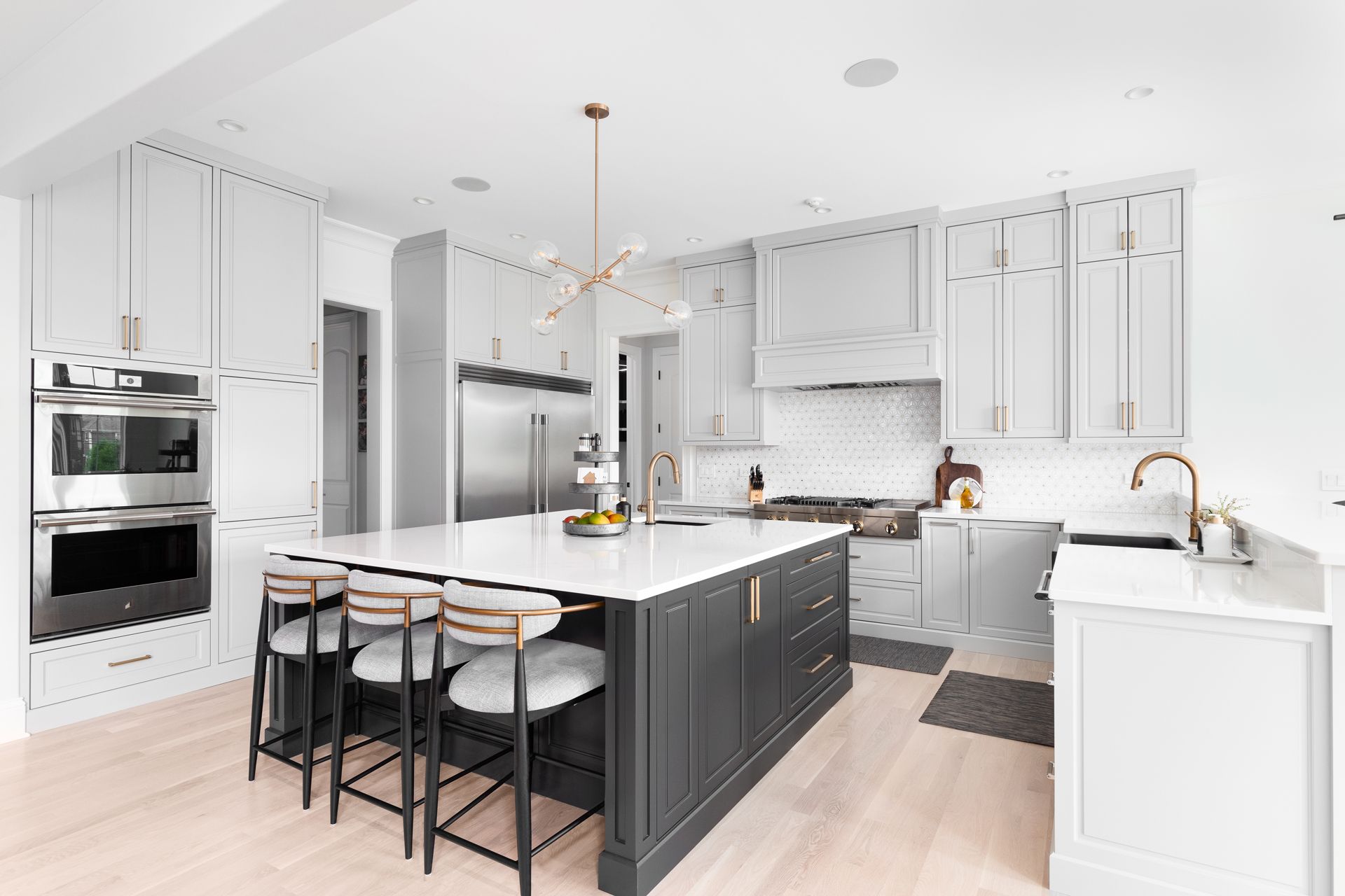 Modern kitchen with white and dark gray cabinetry, island, and stainless steel appliances.