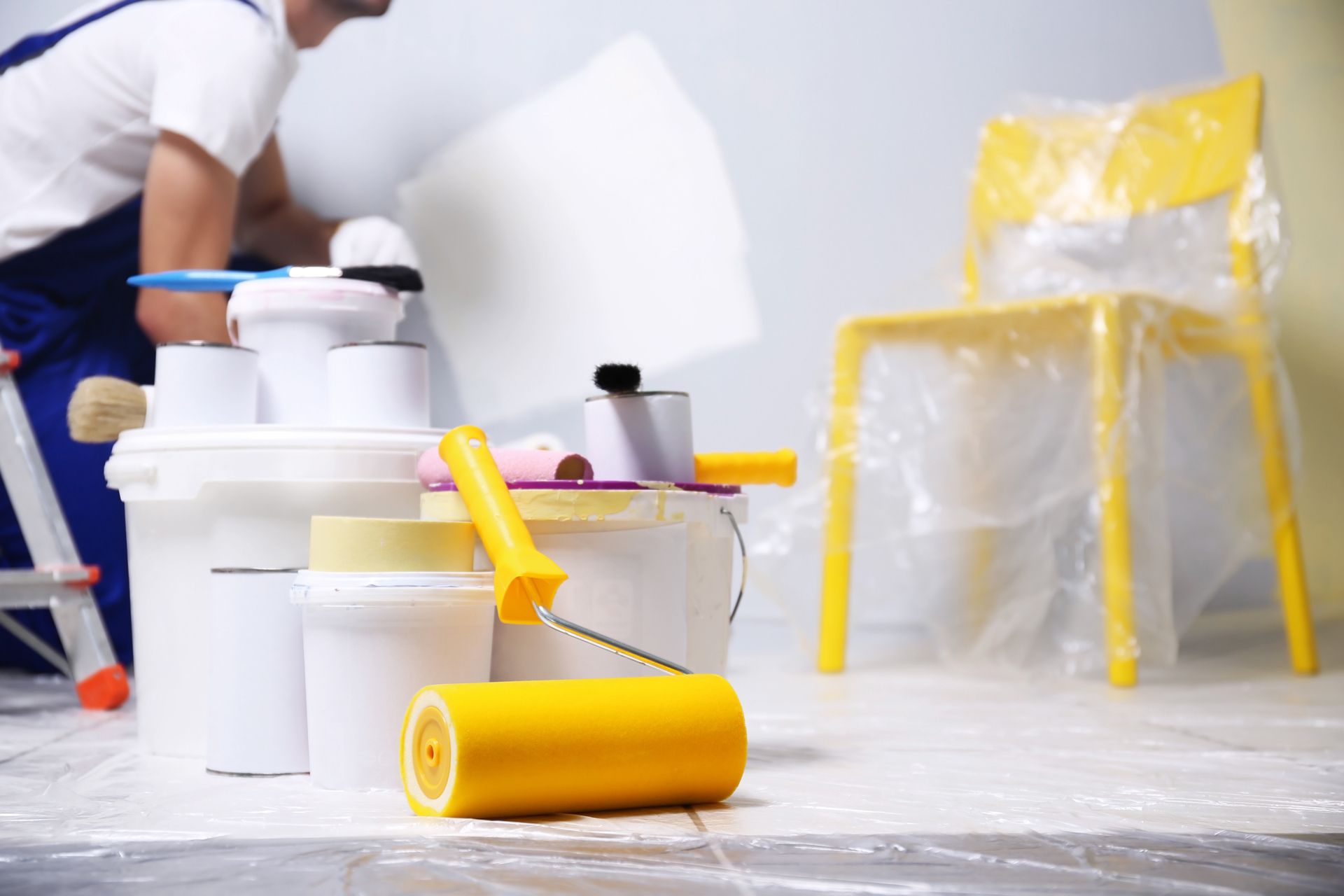 Painter applying white paint to a wall.