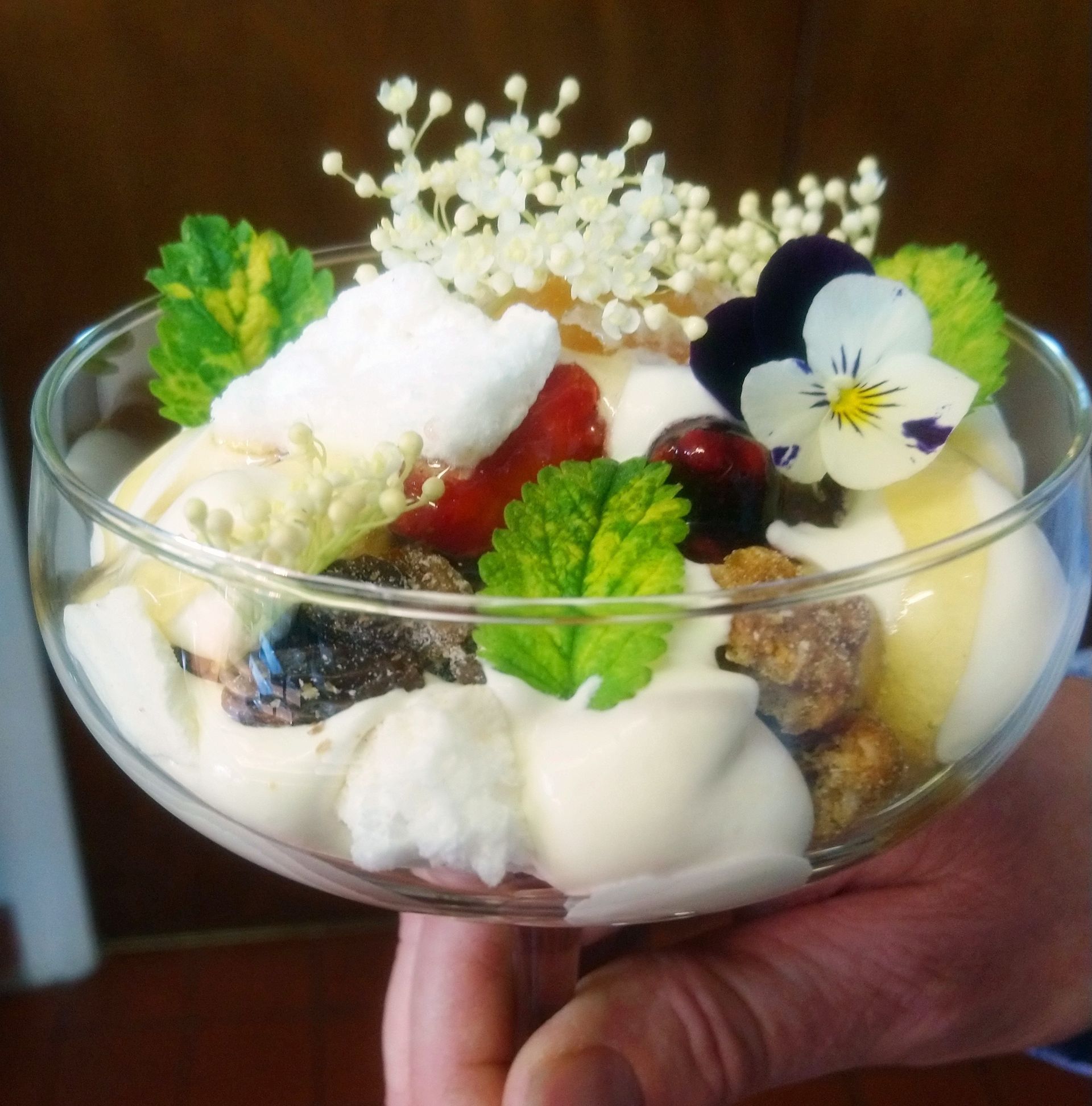 A person is holding a bowl of food with flowers on top