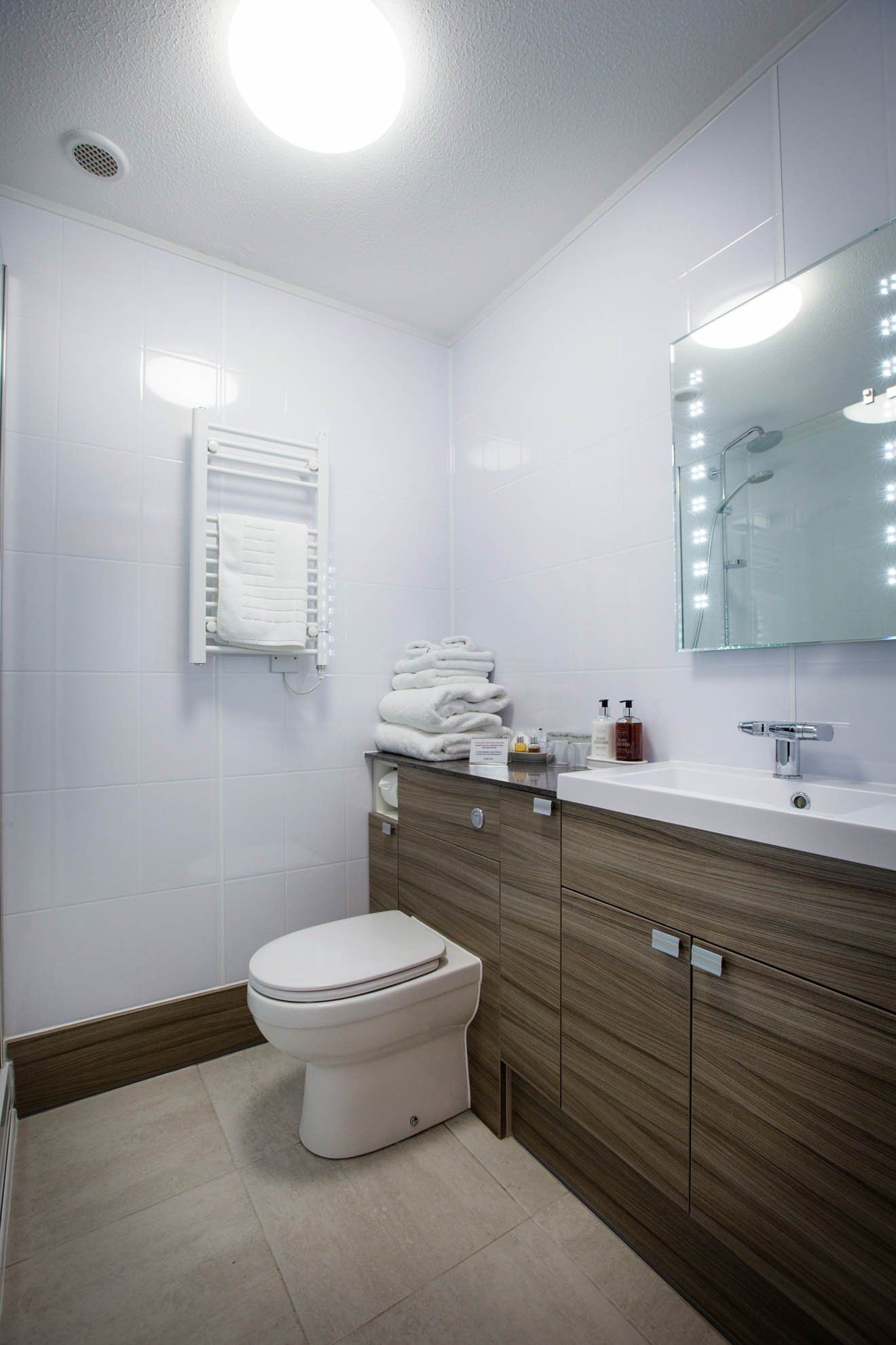 A bathroom with a toilet , sink and mirror.