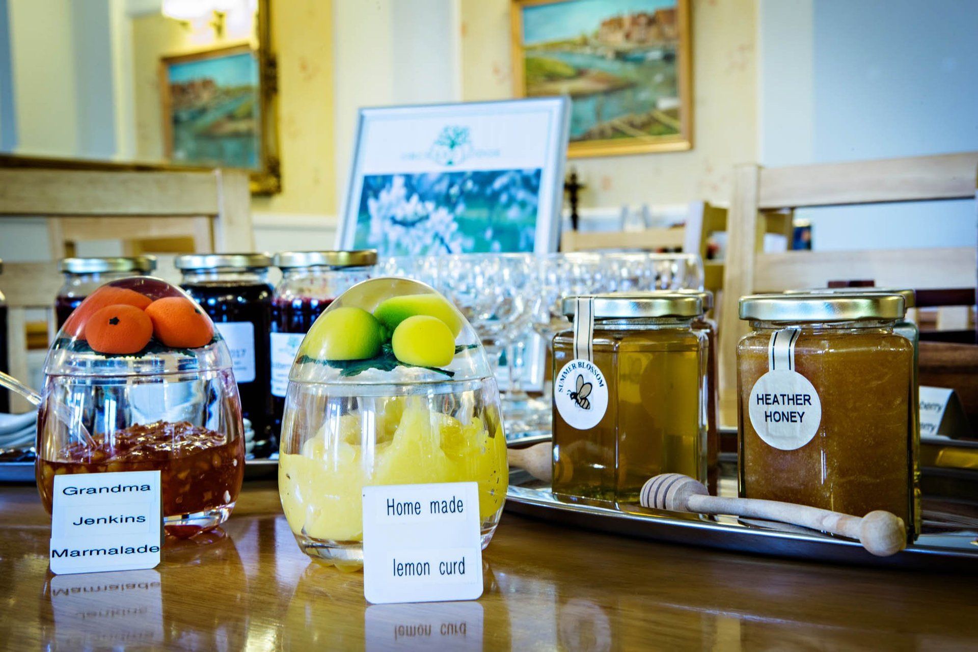 A table with jars of jam and honey on it