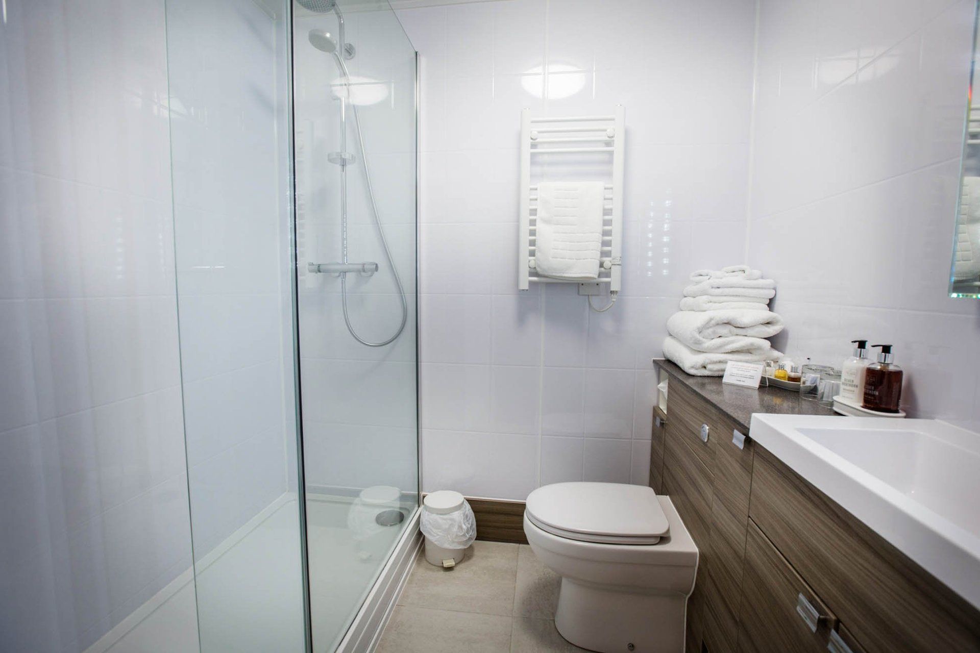A bathroom with a toilet , sink and shower.