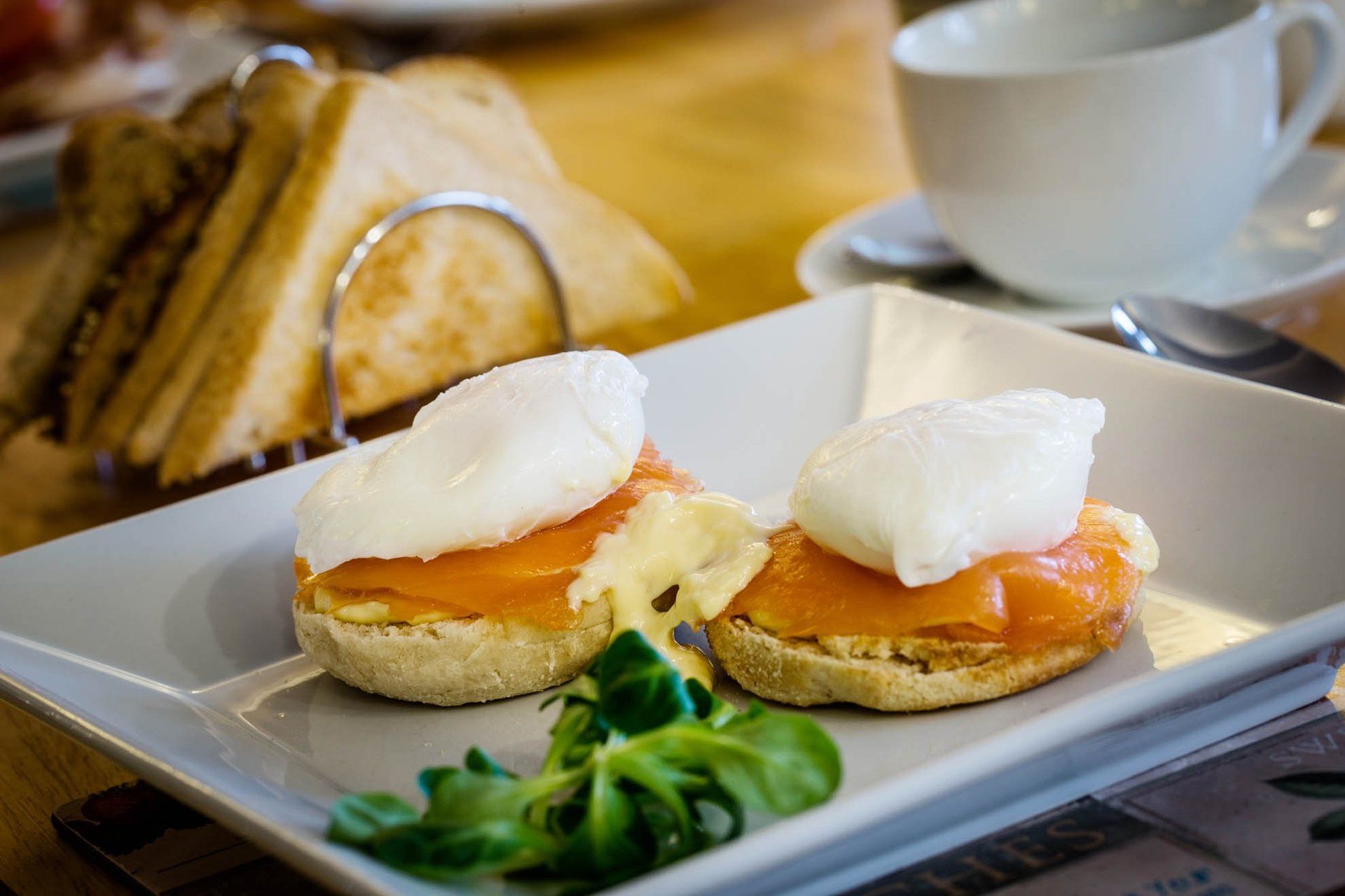 A plate of food with poached eggs and smoked salmon on a table.