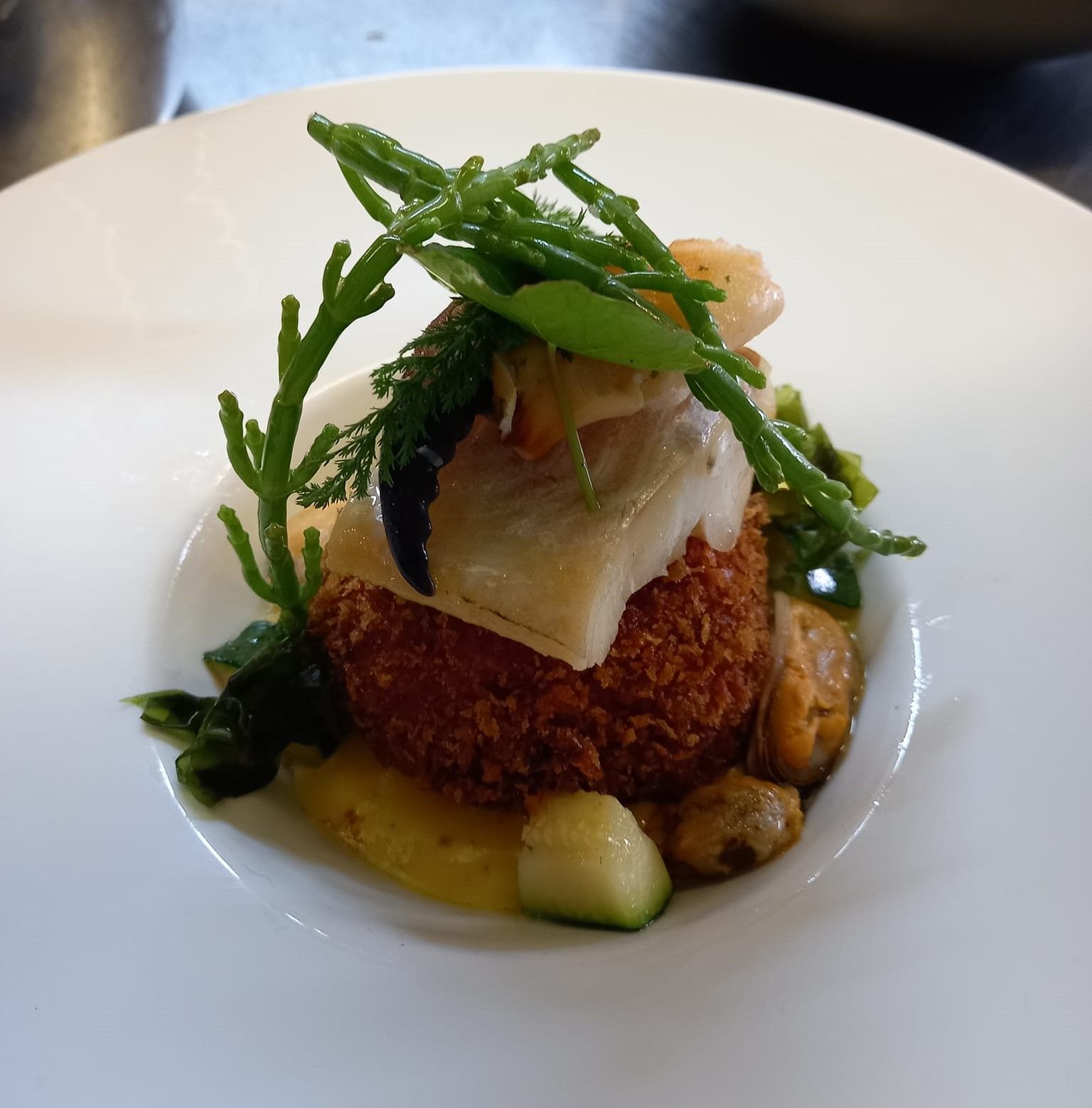 A close up of a plate of seafood with vegetables on top